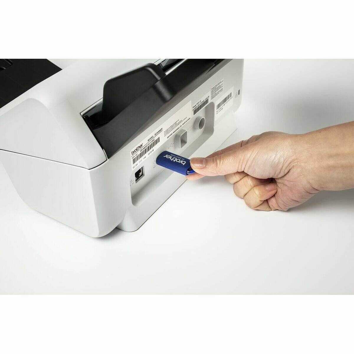 Eine Hand schiebt eine blaue Speicherkarte mit der Beschriftung 