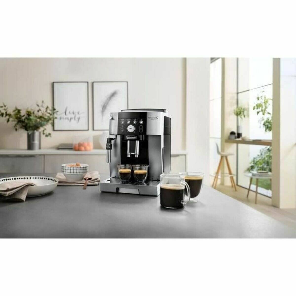 Eine moderne Espressomaschine auf einer Küchenablage braut zwei Tassen Kaffee. Im Hintergrund eine helle Küche mit Dekoration und Pflanzen.