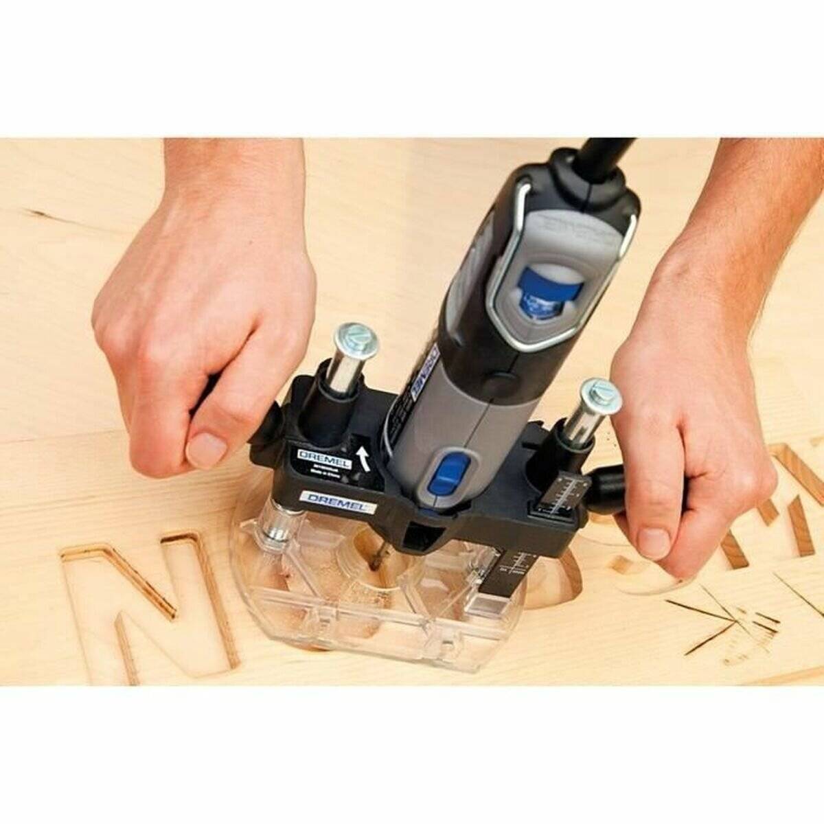 Zwei Hände führen ein Rotationswerkzeug, das 'NEW' in eine Holzoberfläche graviert und dabei präzise Gravur oder Holzbearbeitung demonstriert.