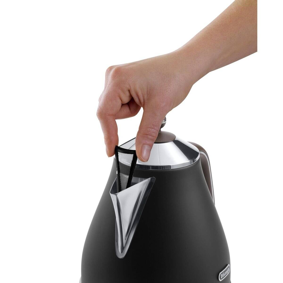 Eine Hand, die einen schwarzen und silbernen elektrischen Wasserkocher-Deckel auf den Wasserkocher setzt und dabei die Benutzerfreundlichkeit hervorhebt.