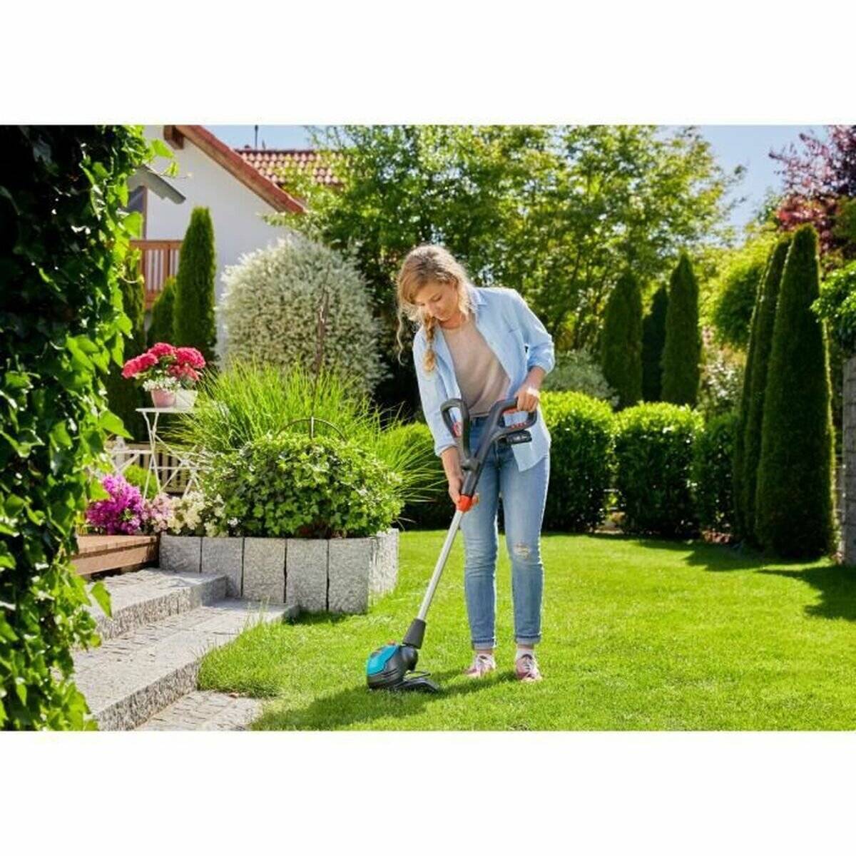 Eine Person trimmt das Gras in einem üppigen, farbenreichen Garten mit einem kabellosen Rasentrimmer, umgeben von lebhaften Pflanzen und einem sonnigen Himmel.