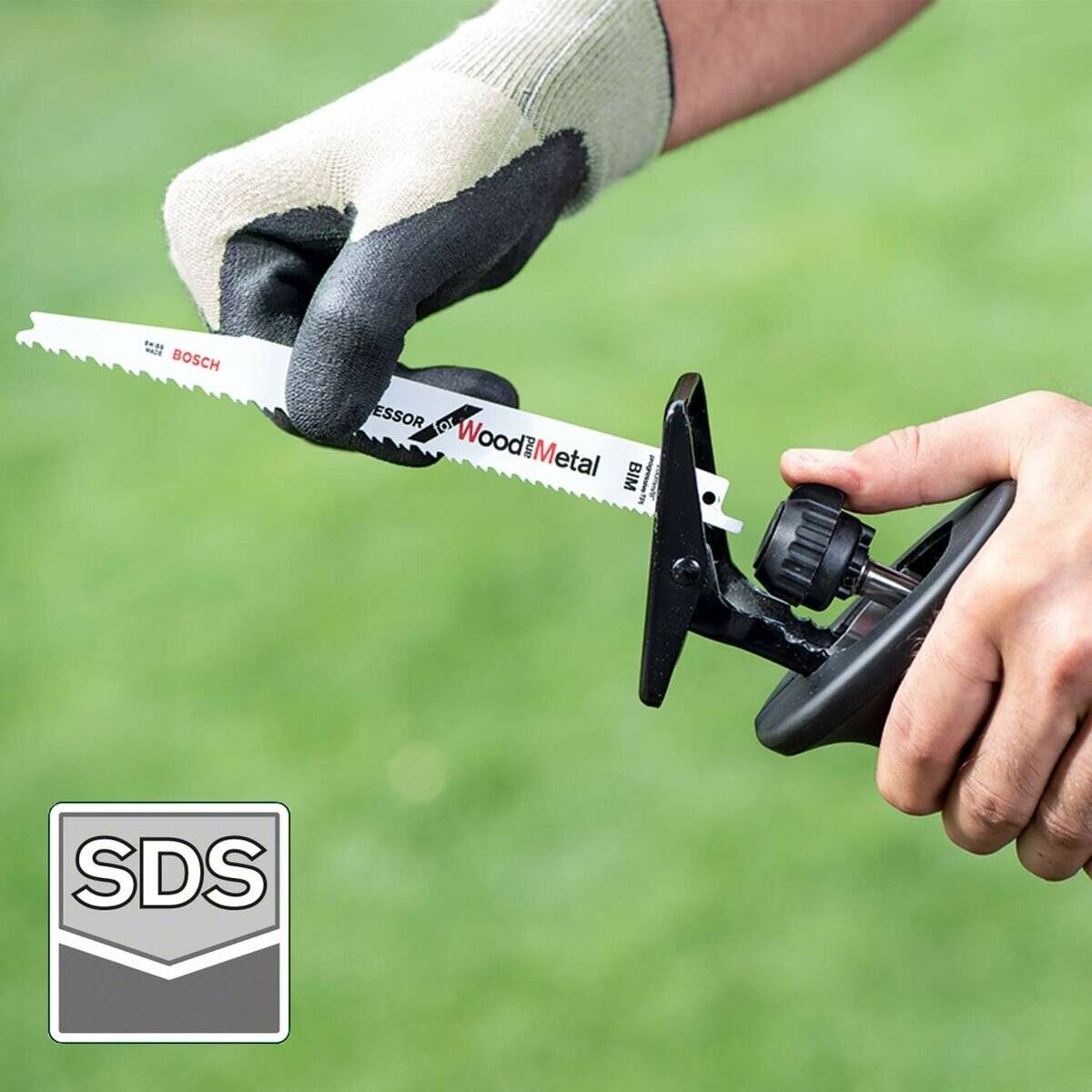 Eine Person mit Handschuhen bringt ein Bosch Holz- und Metallsägeblatt in ein tragbares Werkzeug ein. Das SDS-Logo ist unten links sichtbar.