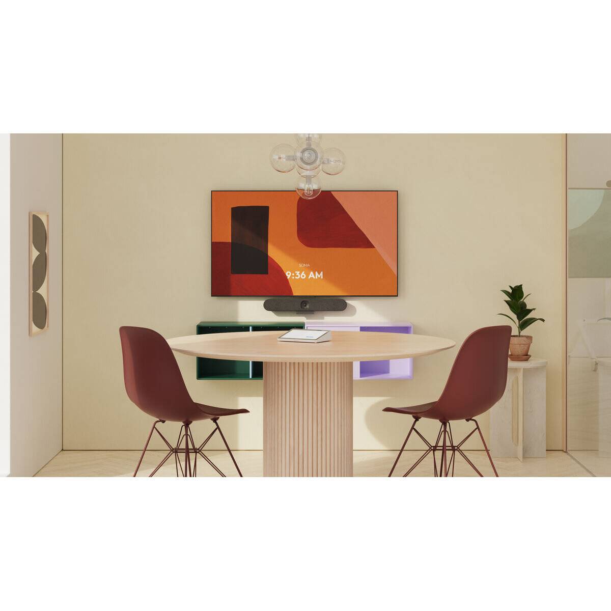 Ein moderner Besprechungsraum mit einem runden Tisch, zwei roten Stühlen, einem Bildschirm, der abstrakte Kunst und '9:36 Uhr' zeigt, und einer kleinen Pflanze an der Seite.