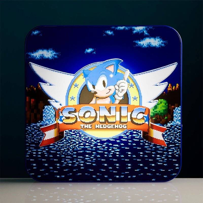 Blaues Spielcover mit dem Logo von 'Sonic the Hedgehog', Sonic-Figur in der Mitte, mit Flügeln und Banner; verpixelter Landschaftshintergrund.