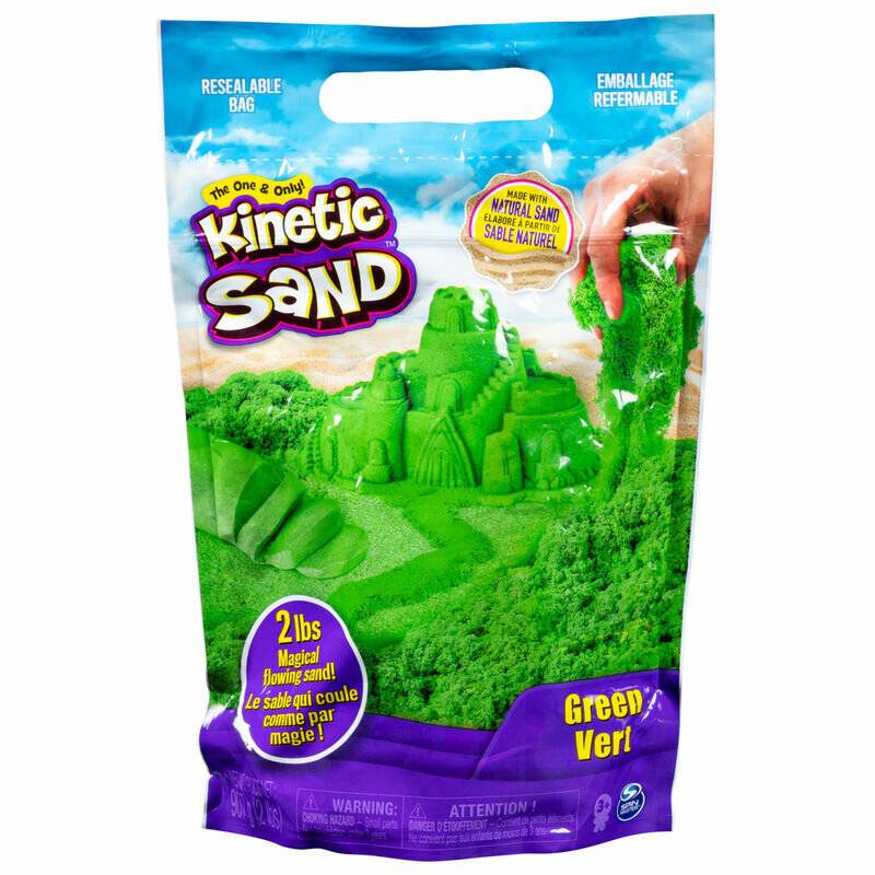 Eine Packung Kinetic Sand mit grünem Sand, der auf der Vorderseite zu einer Burg geformt ist. Darauf steht „Grün