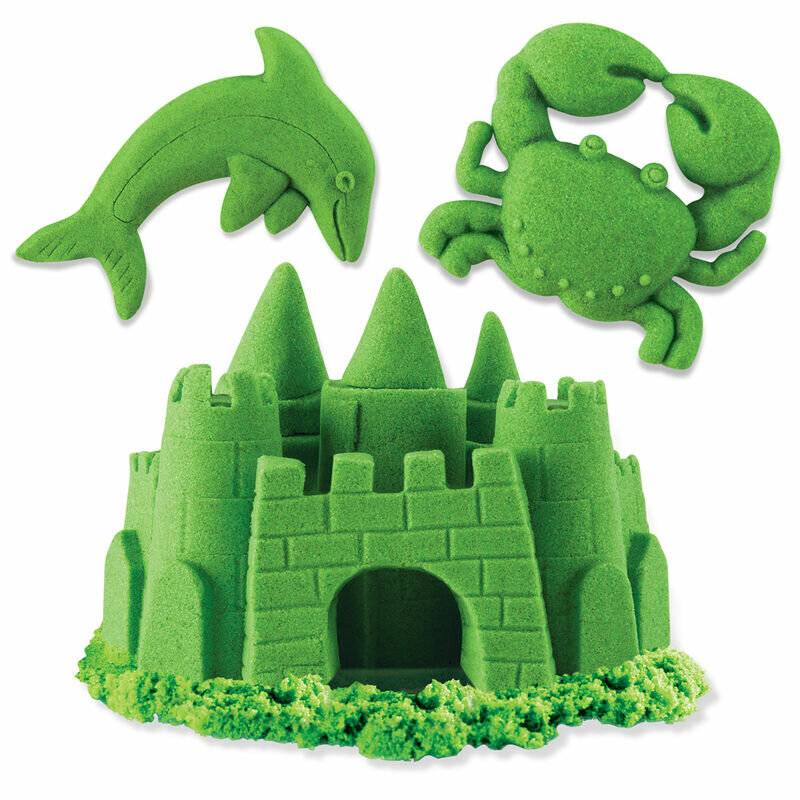 Eine grüne Sandburg mit detaillierten Ziegelmustern steht unter einem springenden Delfin und einem Krebsausschnitt, alle aus grünem Sand gefertigt.