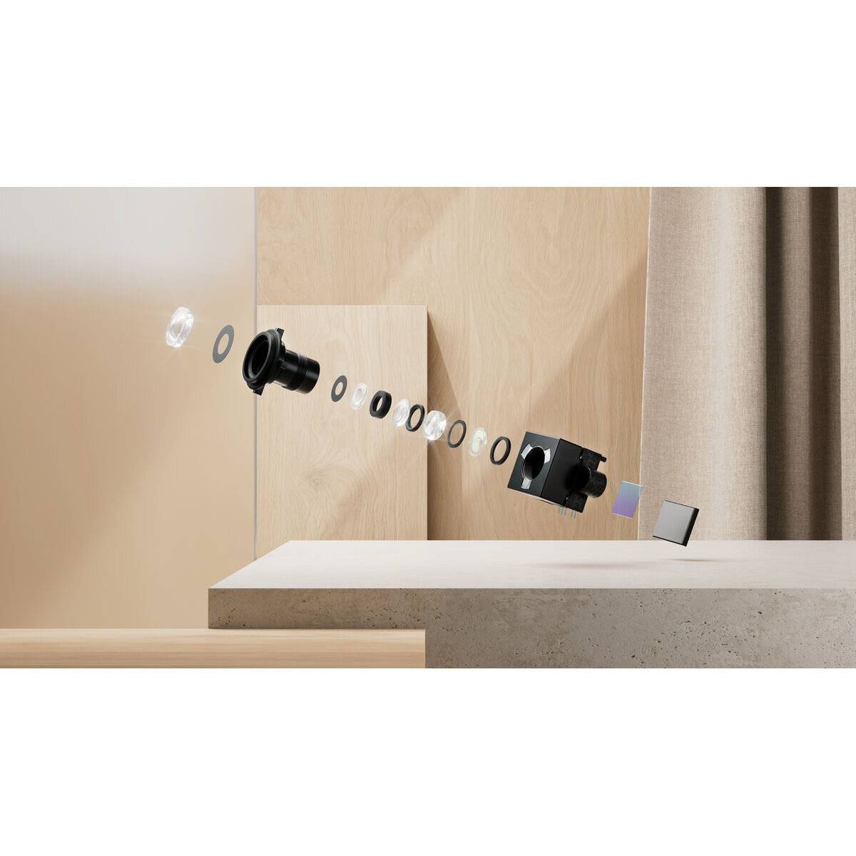 Explosionszeichnung einer Kameraobjektiveinheit, die einzelne Komponenten horizontal angeordnet zeigt, vor einem neutralen Hintergrund.