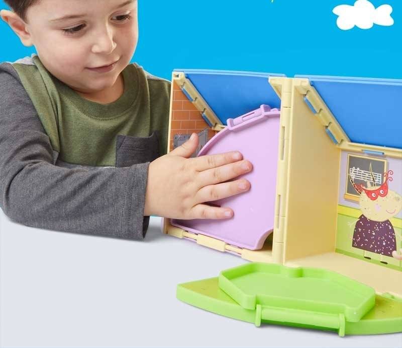 Ein Kind spielt mit einem bunten Spielzeughauspuzzle und fügt ein lila Puzzleteil in das Dach ein, vor einem blau-weißen Hintergrund.
