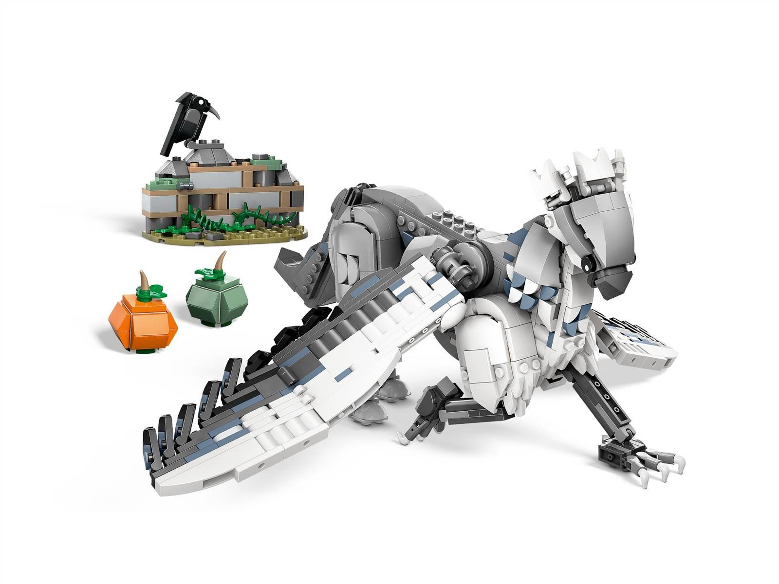 LEGO-ähnlicher weißer Drache mit ausgebreiteten Flügeln neben einem kleinen Felsklippen-Bauwerk und zwei grün-orange Pflanzenelementen auf einem einfachen weißen Hintergrund.