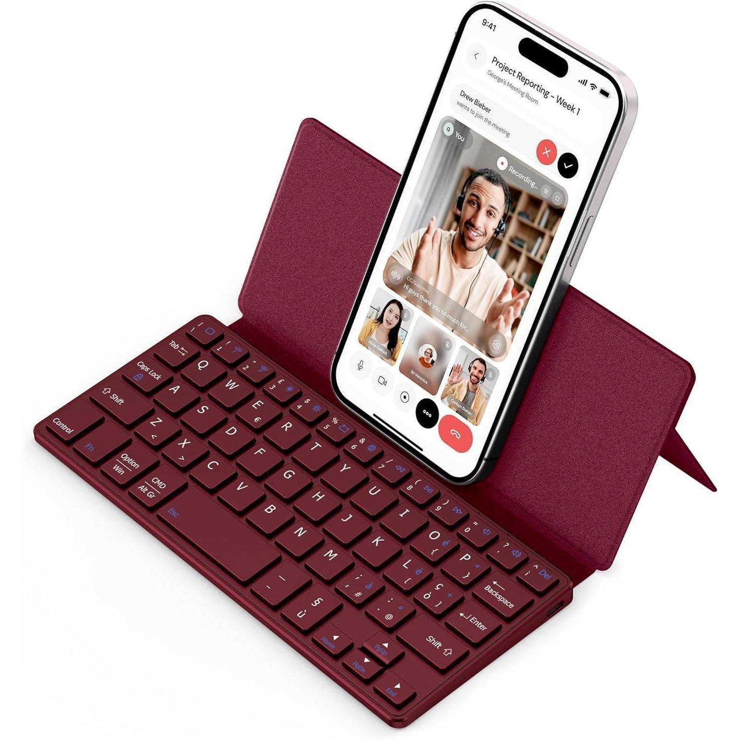 Eine rote drahtlose Tastatur mit einem Telefonständer, der ein Smartphone hält. Auf dem Bildschirm des Telefons wird eine Videokonferenz mit vier Teilnehmern angezeigt.