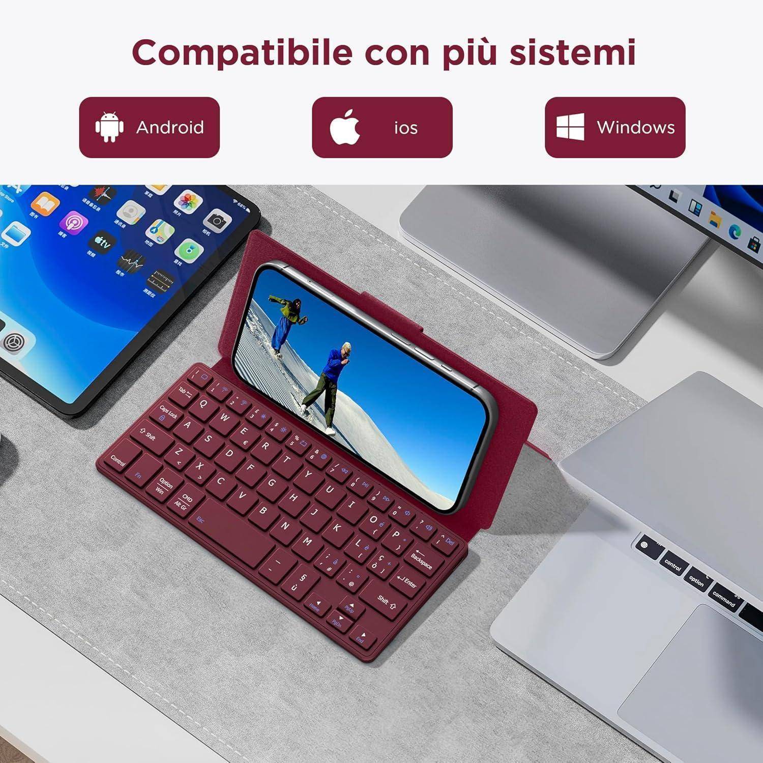 Rote kabellose Tastatur, die ein Smartphone mit einem Ski-Bild hält, umgeben von verschiedenen Geräten. Text: 'Kompatibel mit mehreren Systemen'.
