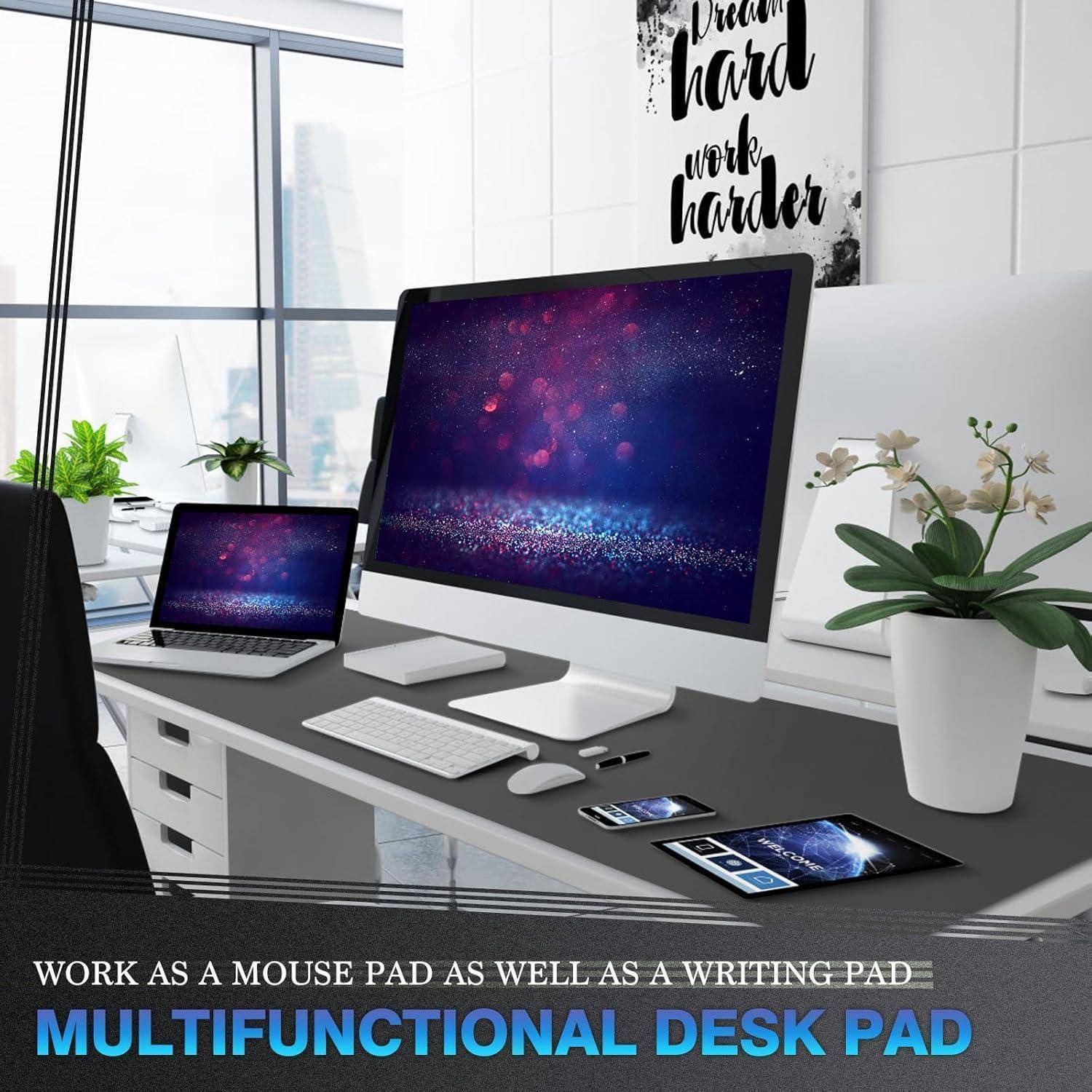 Multifunktionale Schreibtischunterlage auf einem modernen Büro-Schreibtisch-Setup mit Computer, Laptop und Pflanze. Schild liest: „Hart träumen, noch härter arbeiten.