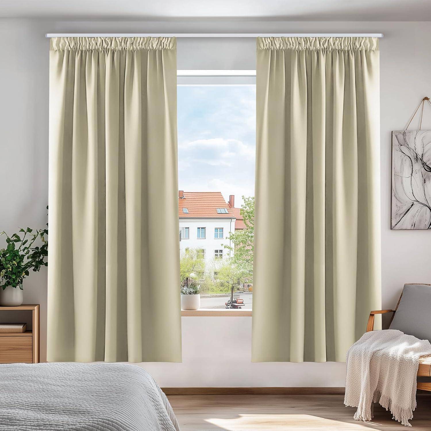 Ein sonnendurchflutetes Schlafzimmerfenster mit beigen Vorhängen blickt auf ein Wohngebiet hinaus. Eine kleine Pflanze sitzt auf der Fensterbank und verleiht dem Raum eine Spur von Grün.