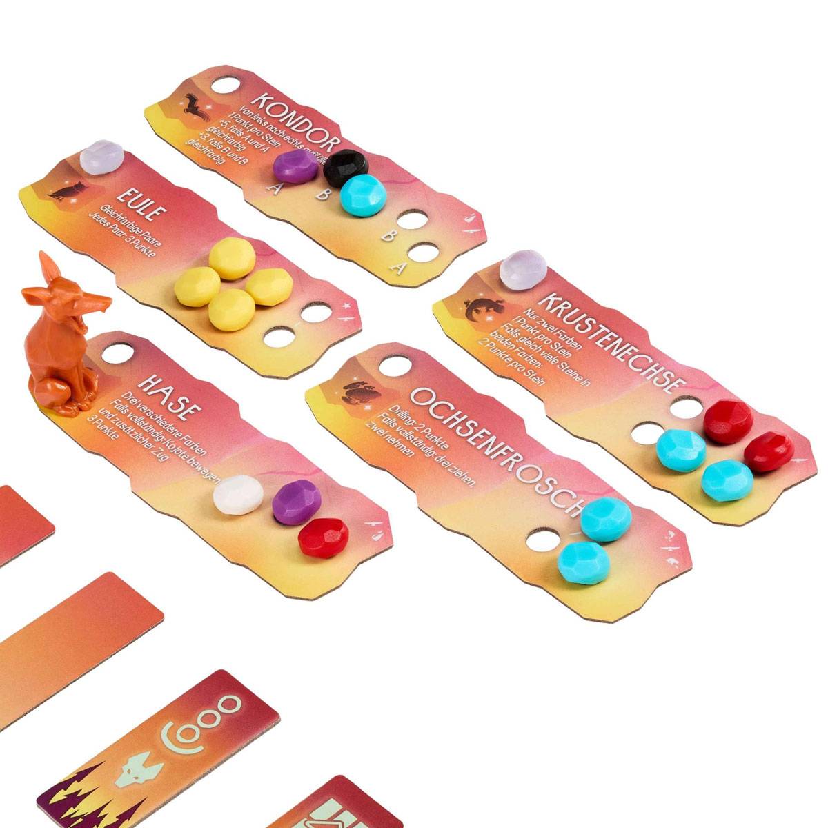 Spielbrettfiguren und Karten mit Beschriftungen 'Fuchs', 'Hase', 'Kondor', 'Krötenechse', 'Ochsenfrosch' mit Tierfiguren und farbigen Spielsteinen.