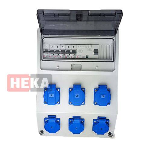 Elektrische Verteilerdose mit sechs blauen Steckdosen und beschrifteten Sicherungsautomaten, teilweise von einem transparenten Deckel abgedeckt.