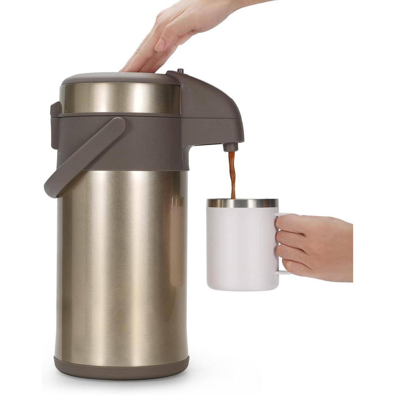 Eine Hand gießt Kaffee aus einem Thermoskanne in eine weiße Tasse, die von einer anderen Hand gehalten wird und damit eine Getränkeservicehandlung veranschaulicht.
