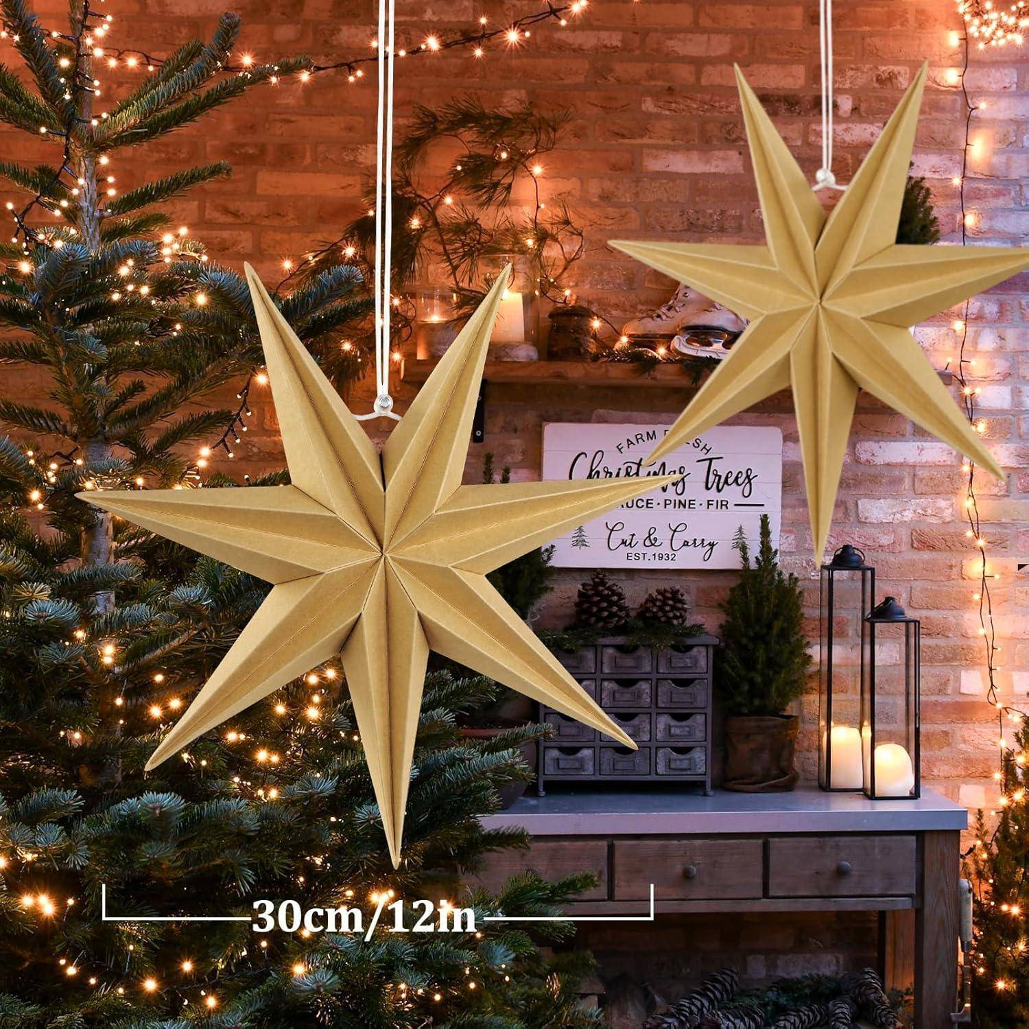 Zwei große goldene sternförmige Ornamente hängen über einem beleuchteten Weihnachtsbaum. Ein Schild liest: „Frisch vom Bauernhof: Weihnachtsbäume