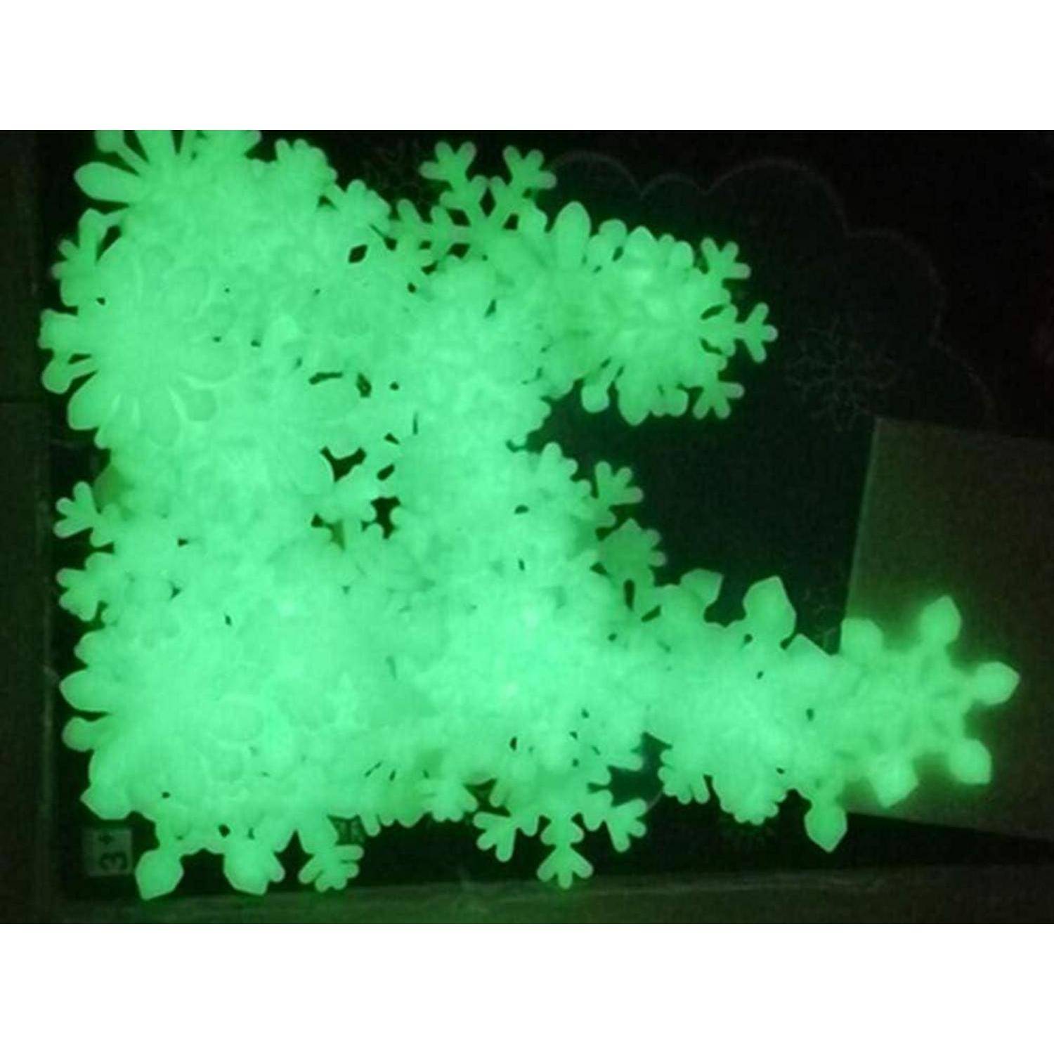 Selbstleuchtende 'Glow in the dark' Schneeflocken-Aufkleber in verschiedenen Größen sind verstreut und strahlen ein helles Grün aus, ähnlich einem winterlichen Schneefall.