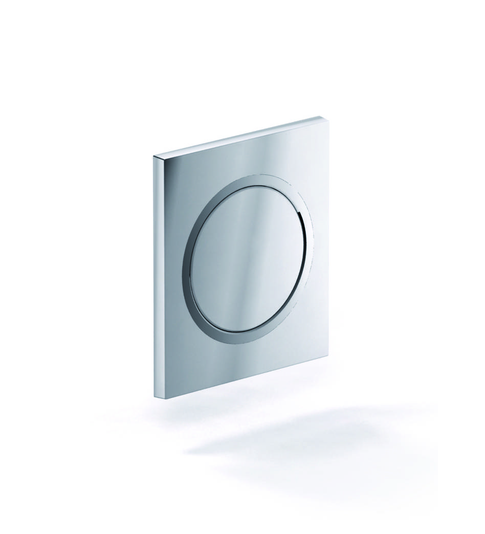 Eine glänzende silberne quadratische Drucktaste mit einer kreisförmigen Druckfläche ist an einer weißen Wand montiert.