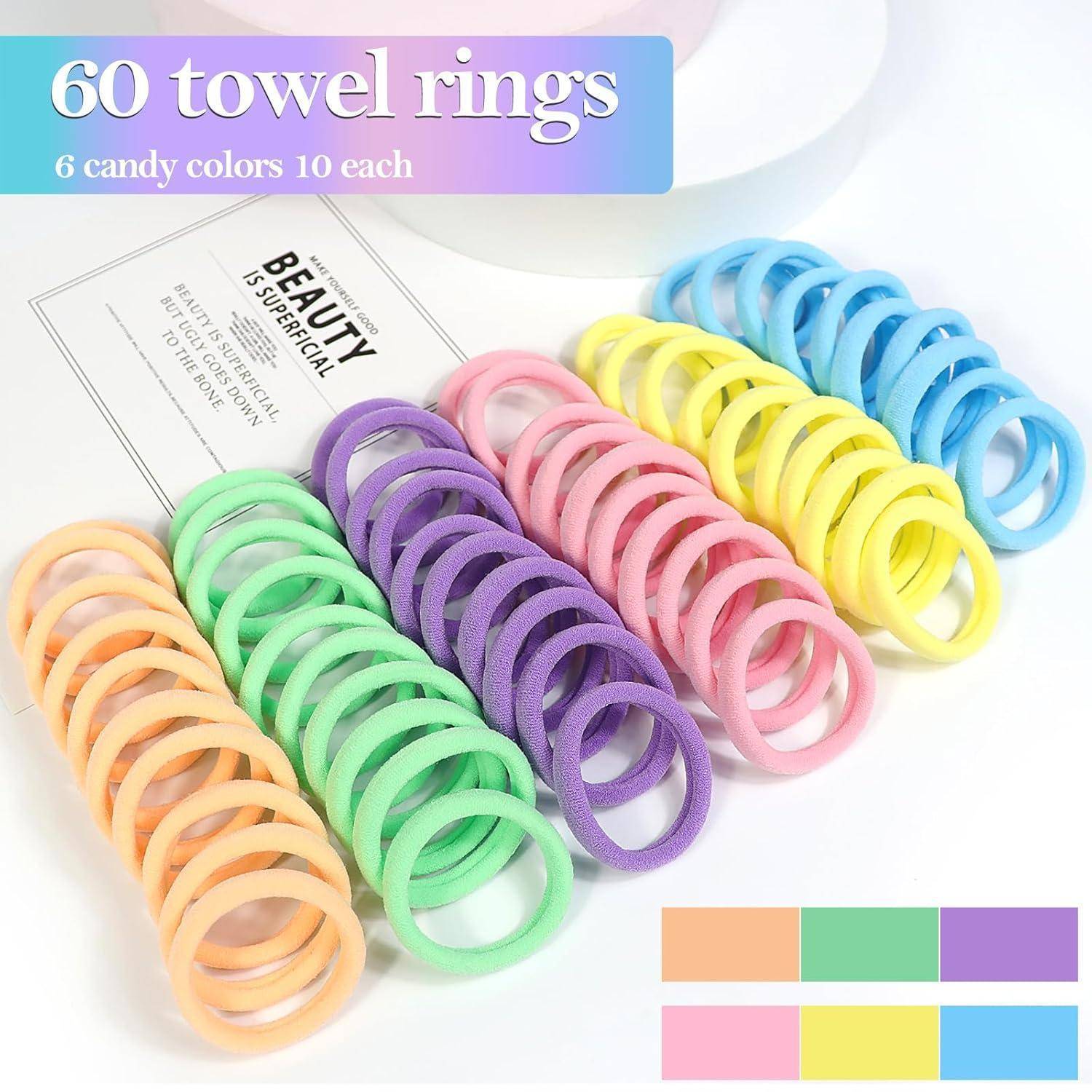 60 Handtuchringe in Pastellfarben: grün, lila, rosa, blau, gelb, orange, je 10 Stück. Etikett liest: „SCHÖNHEIT IST SYMMETRISCH