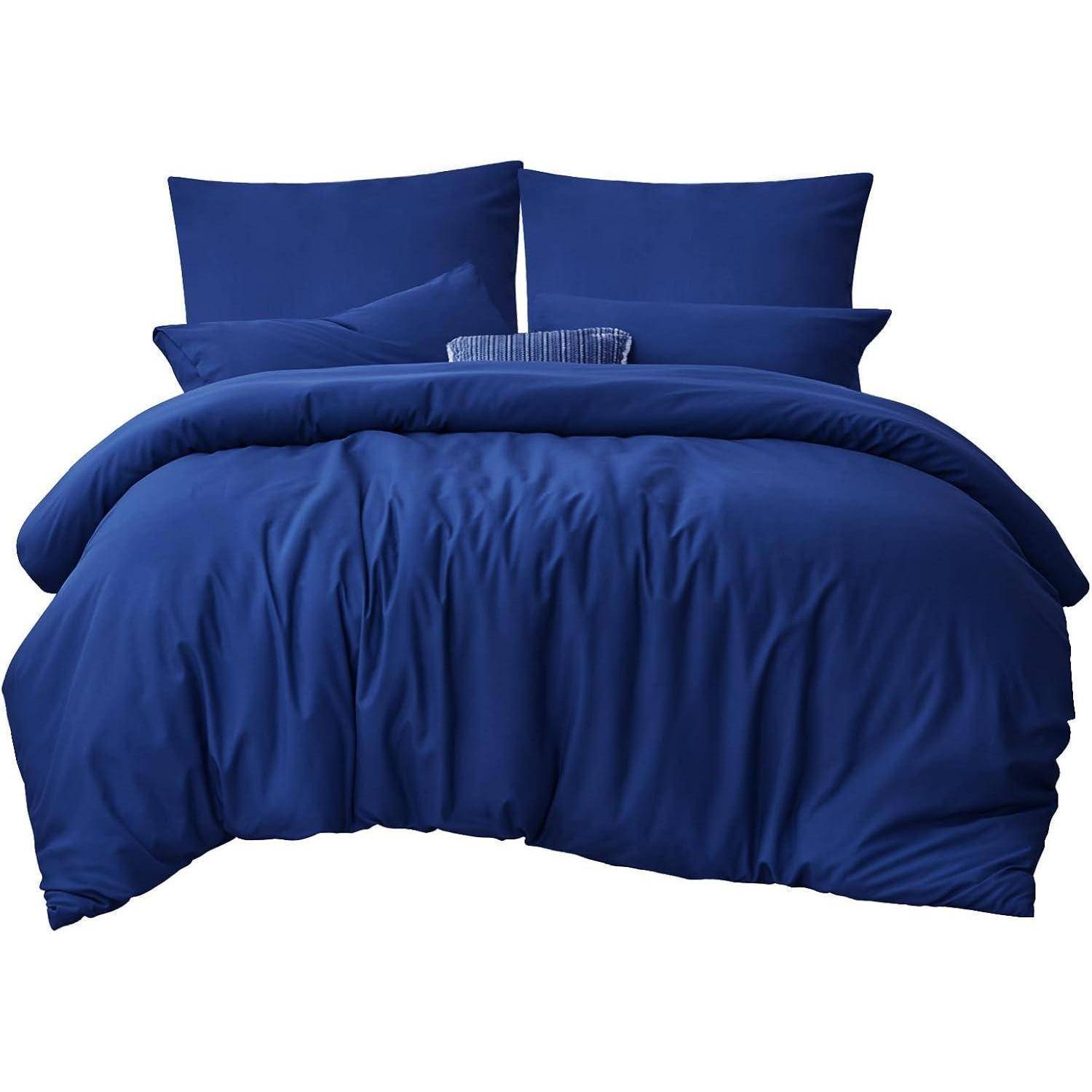 Ein sorgfältig gemachtes Bett mit einer tiefdunkelblauen Bettdecke und Kissen, das ein Gefühl von Gemütlichkeit und Eleganz vermittelt.