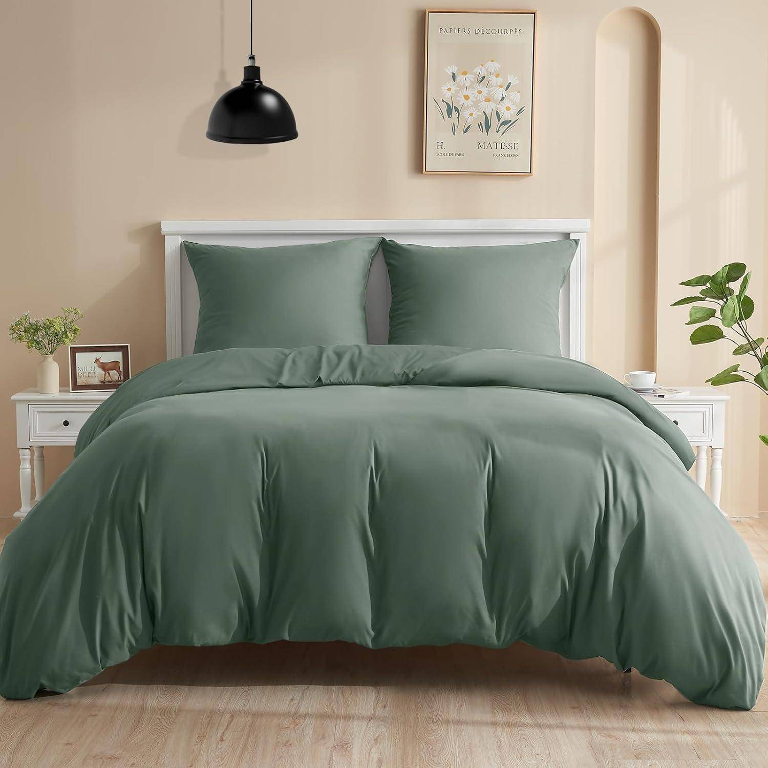Ein ordentlich gemachtes Bett mit grüner Bettwäsche, zwei Kissen und einem weißen Kopfteil. Eine kleine Pflanze und Kunstwerk schmücken den Raum und schaffen eine ruhige Atmosphäre.