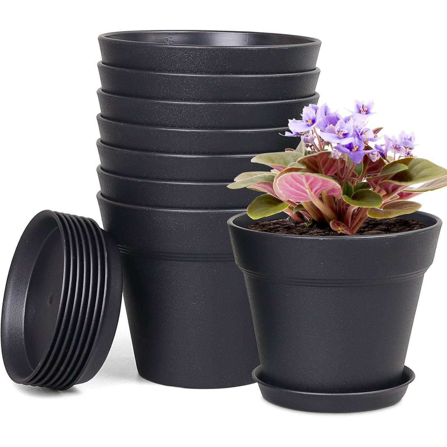 Ein Stapel schwarzer Pflanzentöpfe mit einem Topf, der eine blühende violette und rosa Blume enthält.