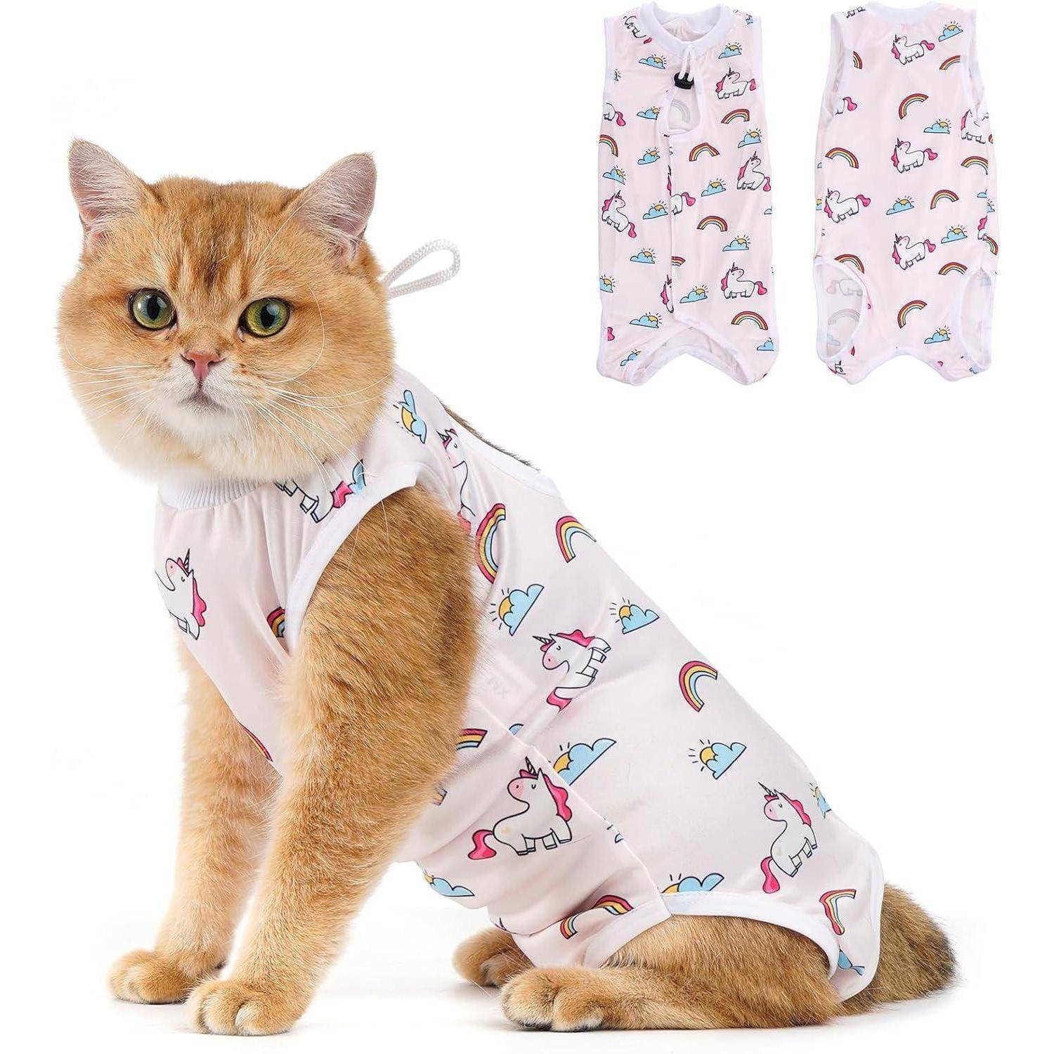 Eine flauschige orange Katze trägt einen weißen Bodysuit mit Einhörnern, Regenbögen und Wolken. Zwei ähnliche Bodysuits sind im Hintergrund ausgestellt.