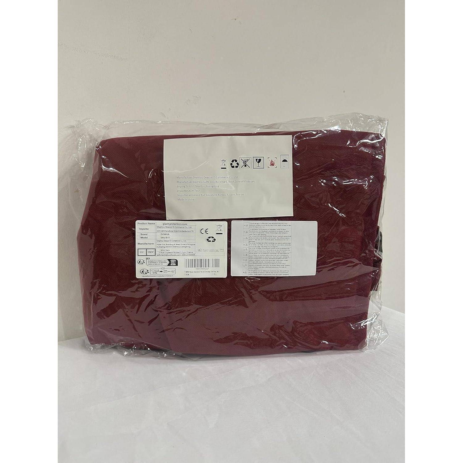 Klare Plastikverpackung, die ein bordeauxrotes Textilprodukt enthält, mit Pflegesymbolen und Text beschriftet, vor einem einfarbigen weißen Hintergrund.