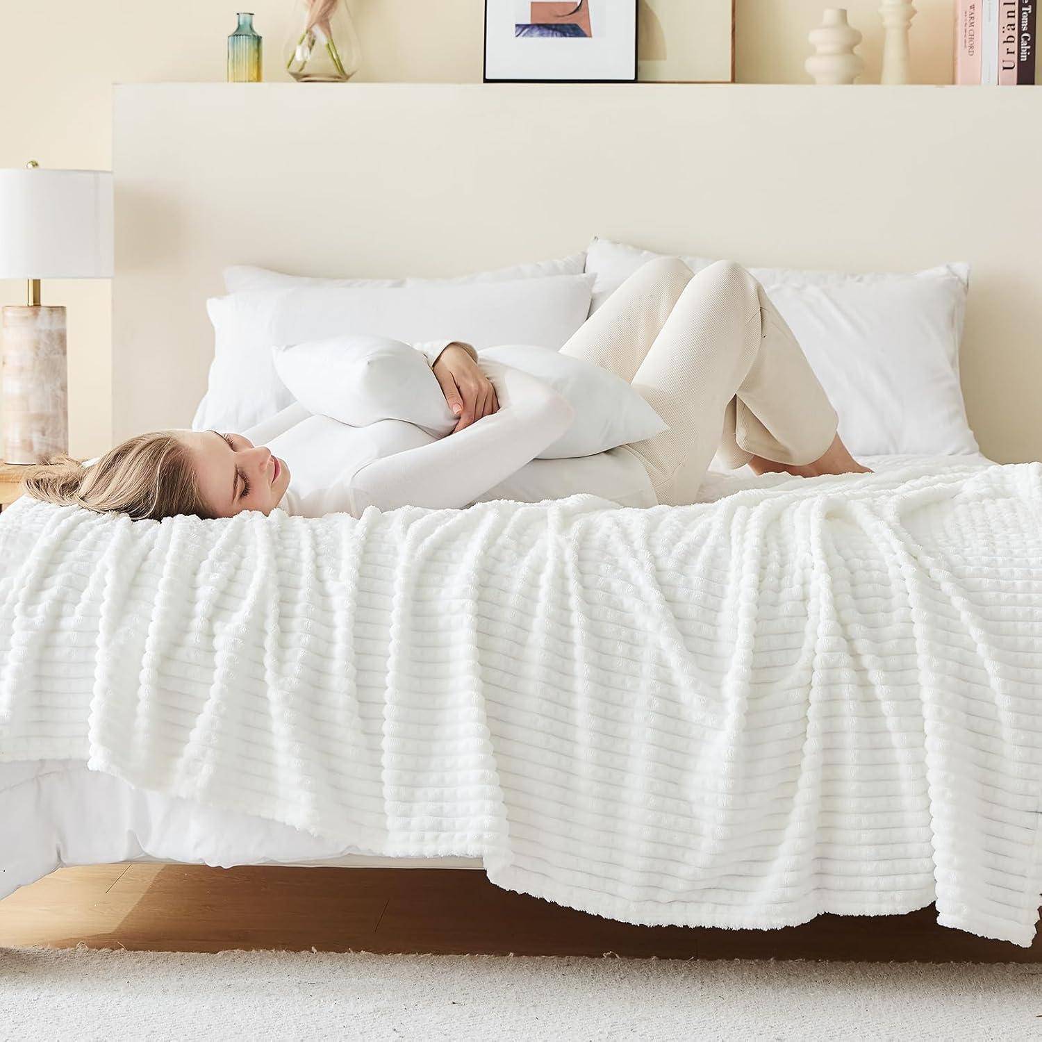 Eine Person liegt entspannt auf einem Bett und hält ein weißes Kissen, in einem hellen, minimalistisch eingerichteten Schlafzimmer.