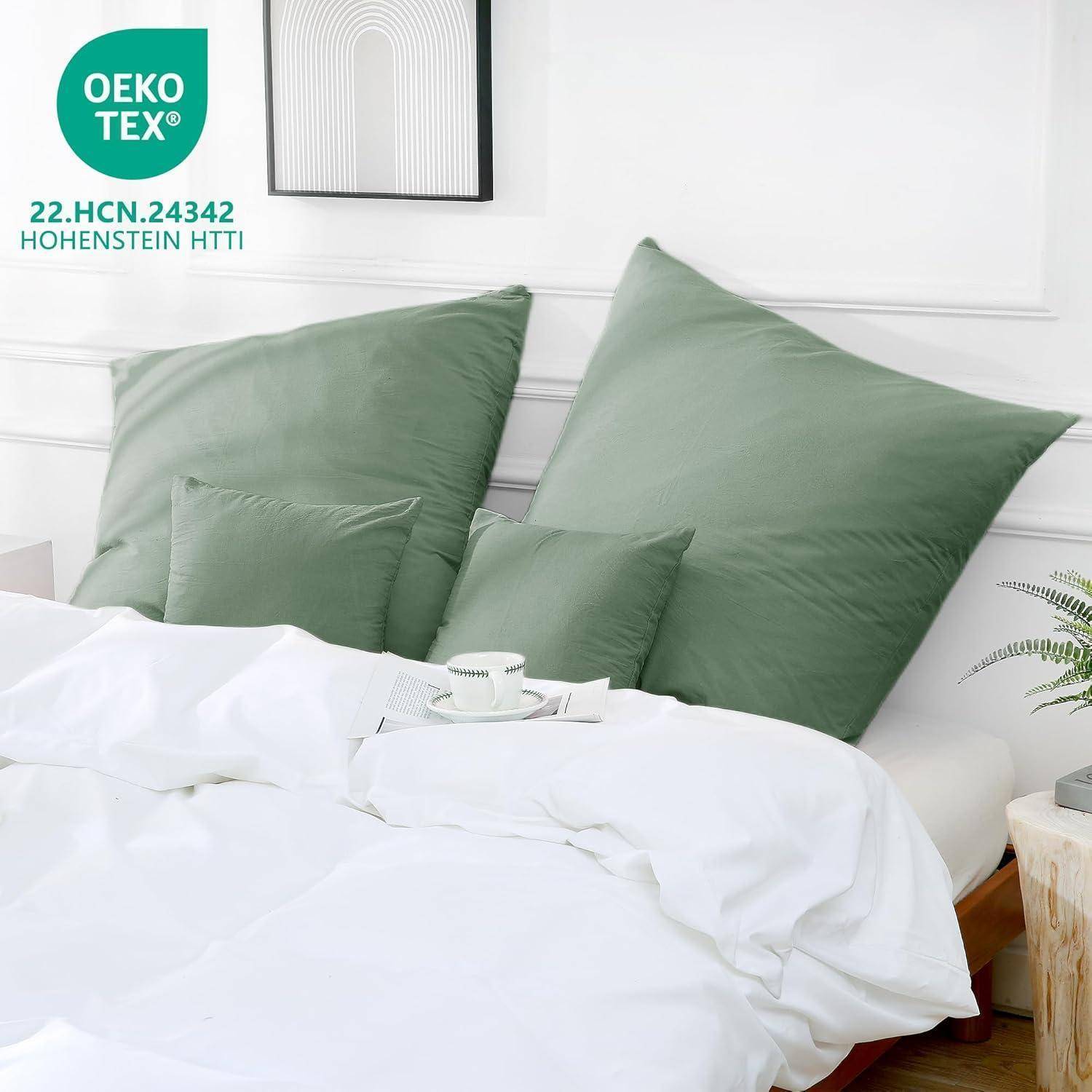 Ein ordentlich gemachtes Bett mit grünen Kissen und einer weißen Bettdecke, mit einer Tasse auf dem Bett. Das OEKO-TEX-Siegel weist auf eine umweltfreundliche Zertifizierung hin.
