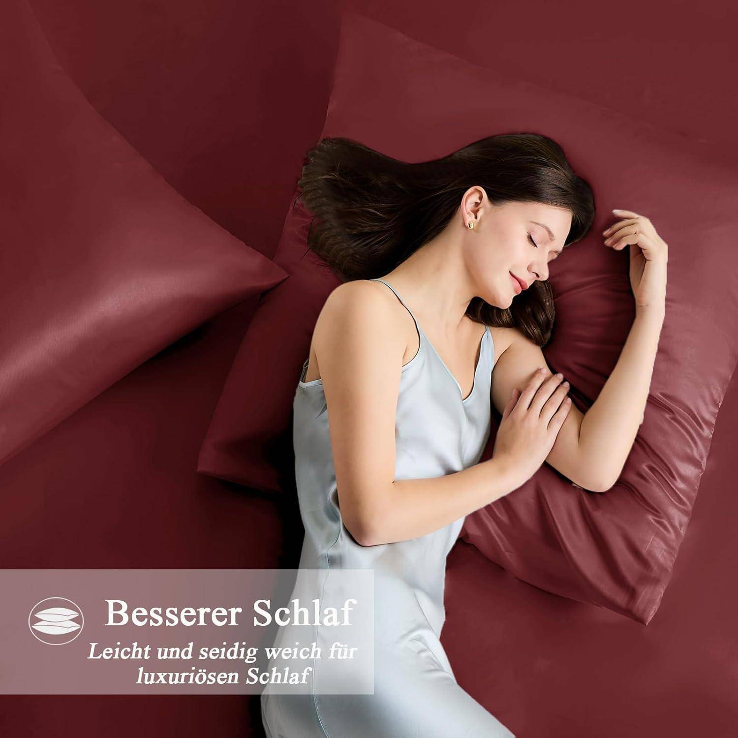 Eine Frau schläft friedlich auf roter Bettwäsche. Der Text im Bild lautet: „Besserer Schlaf. Leicht und seidig weich für luxuriösen Komfort.