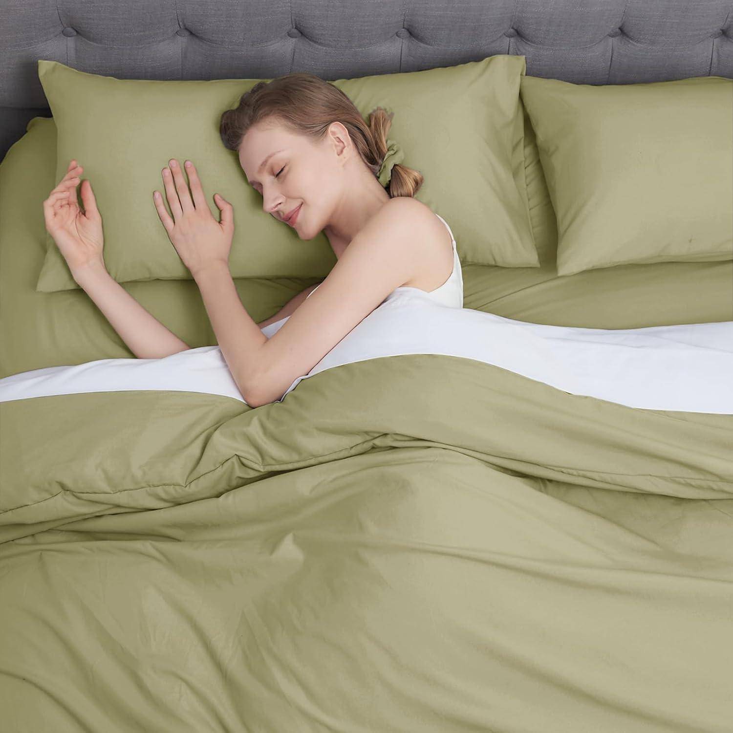 Eine Person, die friedlich auf einem Bett mit grüner Bettwäsche schläft, den Kopf auf einem Kissen ruhend, in einer ruhigen und beschaulichen Umgebung.