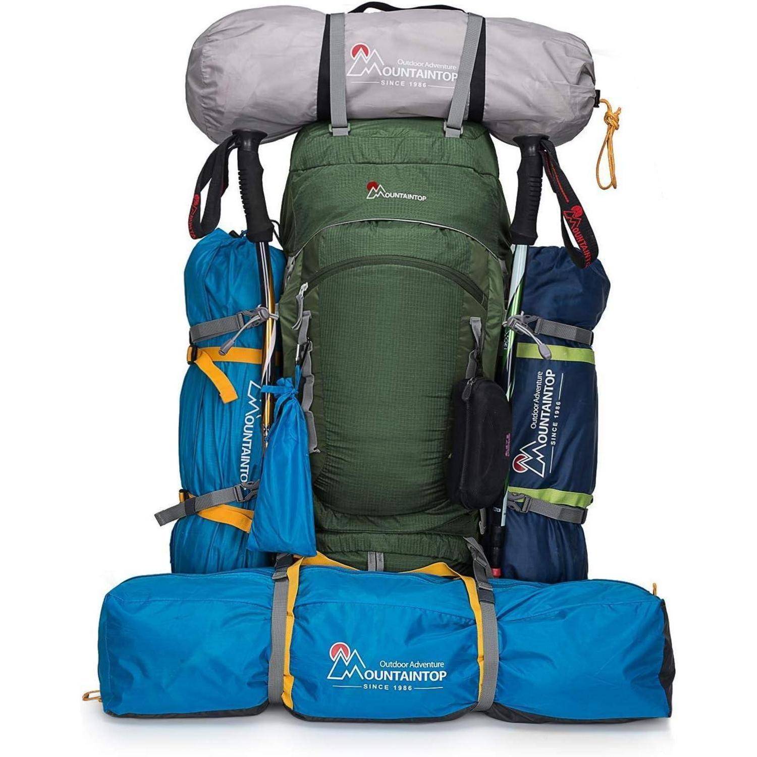 Ein großer grüner Rucksack mit mehreren Fächern und verschiedener Campingausrüstung wie Schlafsäcken und Zelten, die an den Seiten befestigt sind.