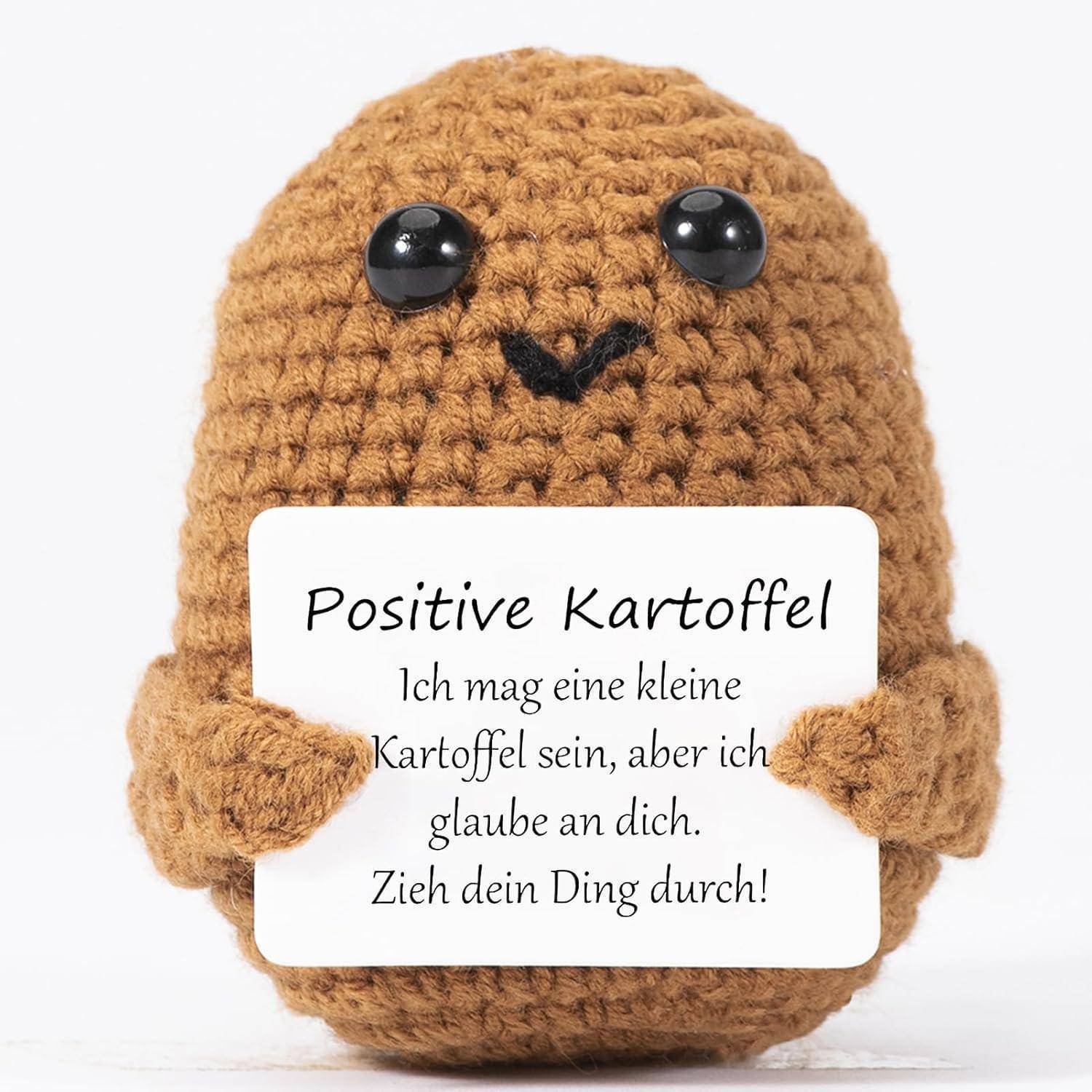 Ein gehäkelter Kartoffelcharakter hält ein Schild mit der Aufschrift 