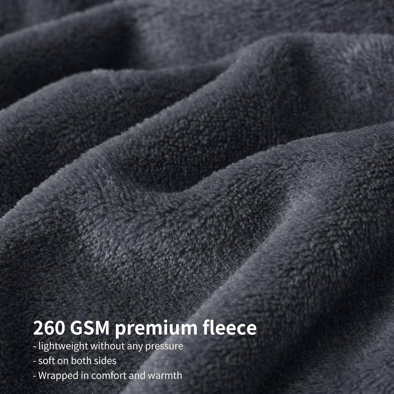 Nahaufnahme von weichem grauem Fleecestoff mit Text: '260 GSM Premium-Fleece - leicht ohne Druck - auf beiden Seiten weich - gehüllt in Komfort und Wärme'.