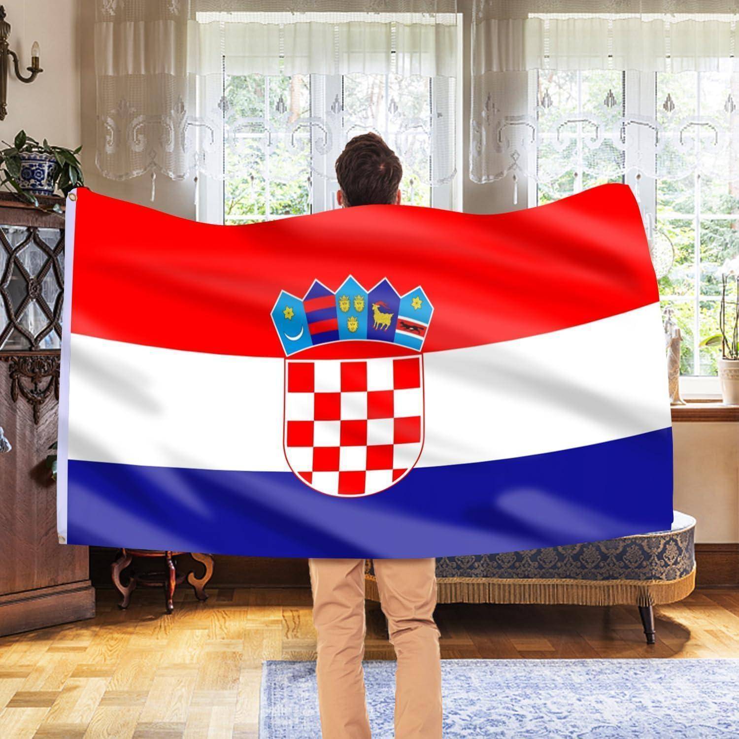 Eine Person steht drinnen, eingehüllt in eine große kroatische Flagge, die deren rot-weiß-blaue Streifen und das karierte Wappen präsentiert.