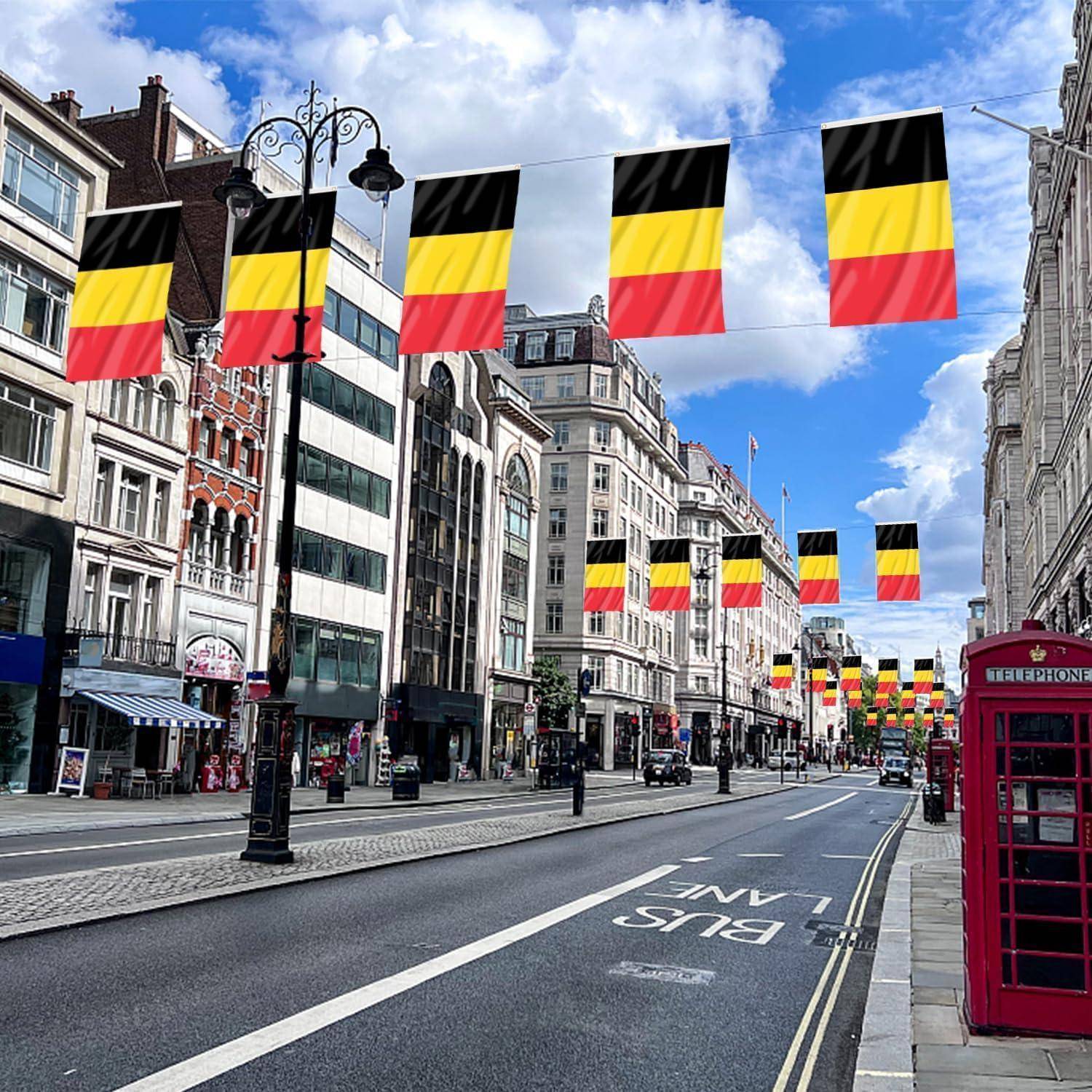 Eine Stadtstraße mit Gebäuden auf beiden Seiten, geschmückt mit Reihen von schwarzen, gelben und roten Flaggen. Eine rote Telefonzelle befindet sich auf der rechten Seite.