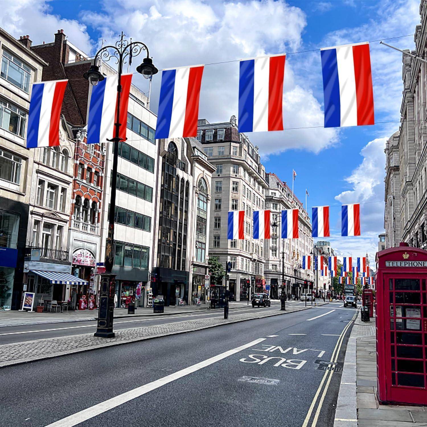 Eine Straße, gesäumt von britischen Häusern im Stil des Vereinigten Königreichs und rot, weiß und blauen Fahnen, die über der Straße hängen. Eine rote Telefonzelle ist rechts zu sehen.