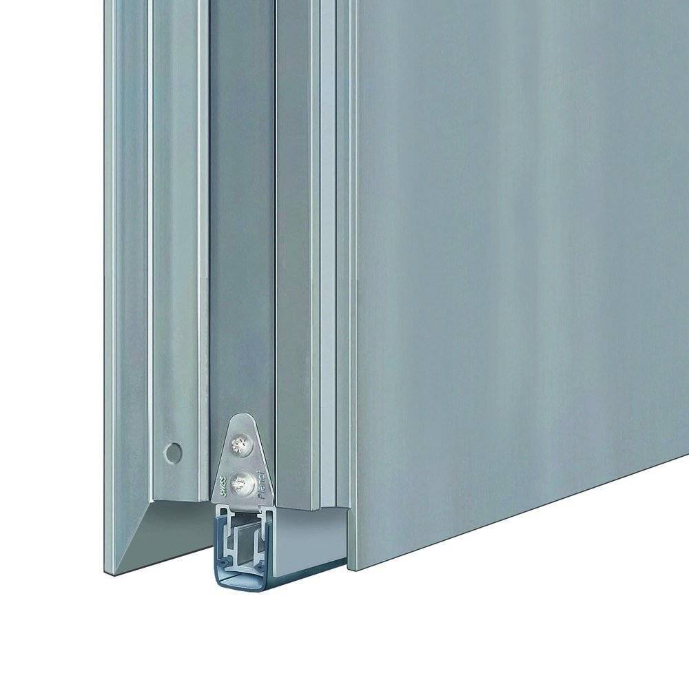 Eine Nahaufnahme eines silbernen Metallrahmens, möglicherweise Teil eines Schiebe- oder Falttürmechanismus, mit aufwendigen Details in der Ecke.