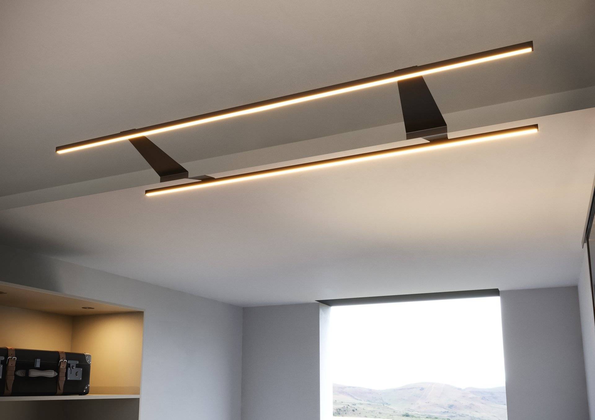 Eine moderne Decke mit eleganten, eingelassenen Leuchten und einem rechteckigen Fenster mit Aussicht auf entfernte Hügel.