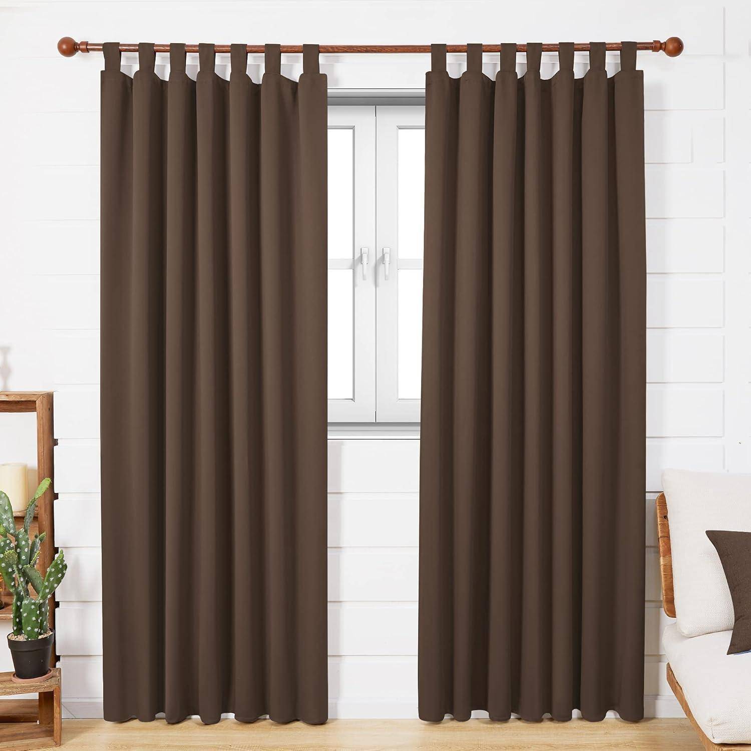 Braune Vorhänge, die an einem Fenster in einem weißen Raum mit Pflanzen und einem Kissen hängen.