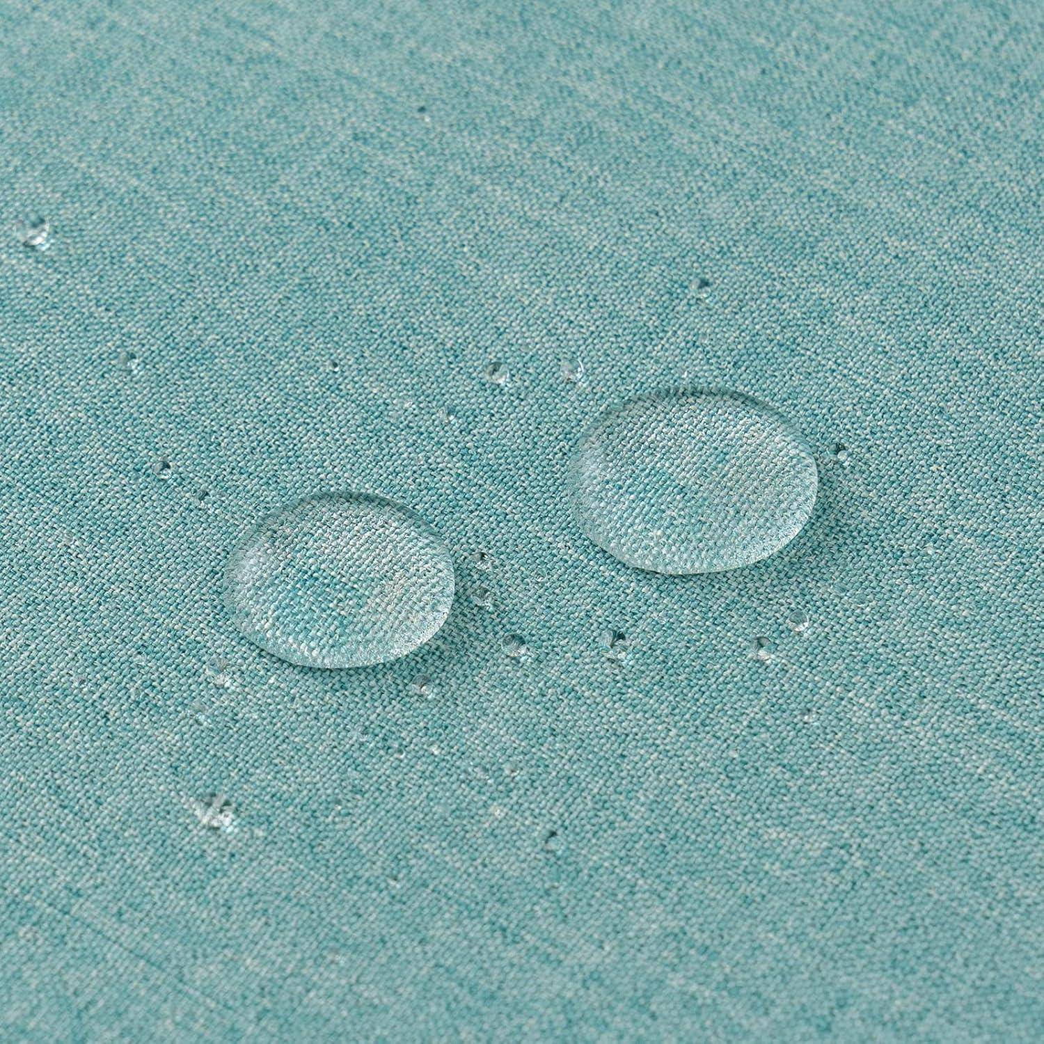 Zwei klare Wassertropfen sitzen auf einer türkisfarbenen Stoffoberfläche und demonstrieren die wasserabweisende Eigenschaft des Materials.