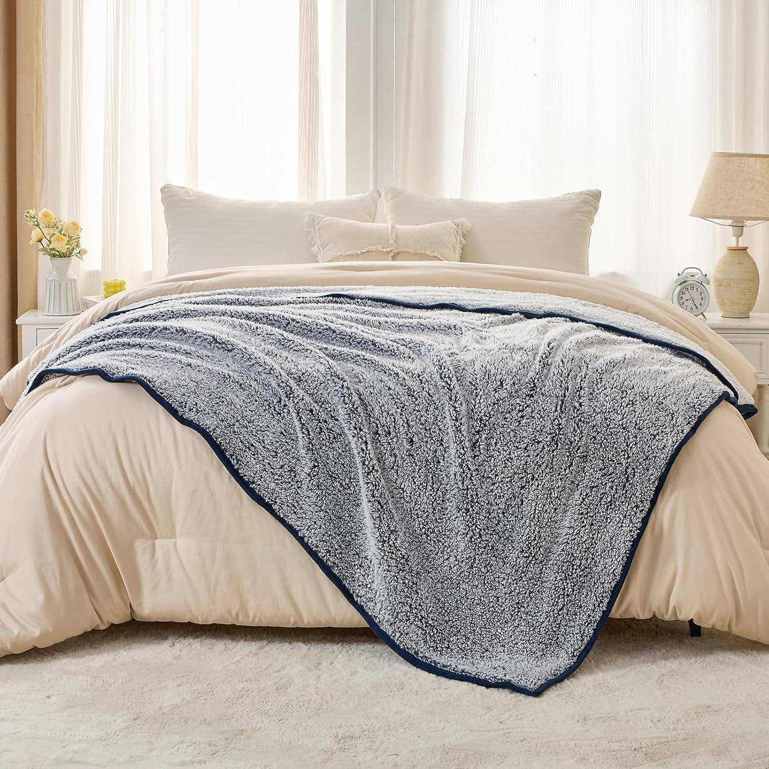 Ein ordentlich gemachtes Bett mit einer flauschigen grauen Decke, die über einem cremefarbenen Bettdecken liegt. Der Raum hat sanftes Licht und eine ruhige, einladende Atmosphäre.