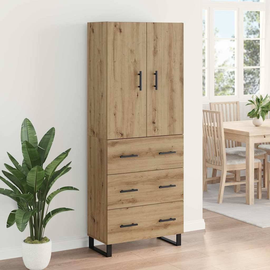 Holzschrank mit drei Schubladen und zwei Türen, schwarze Griffe, neben einer Zimmerpflanze. Esstisch und Stühle sind durch die Türöffnung sichtbar.