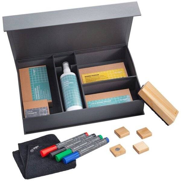 Offene schwarze Präsentationsbox mit beschrifteten Bastelmaterialien, einschließlich Markern, Klebstoffflasche, Stoffbeutel und kleinen Holzblöcken.