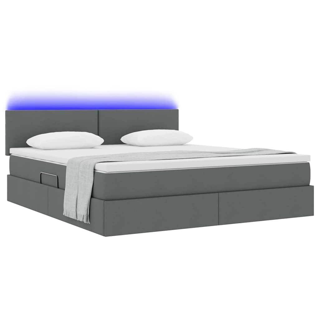 Ein modernes graues Bett mit Schubladen zur Aufbewahrung, zwei weißen Kissen, einer weißen Decke und einem blau beleuchteten Kopfteil.