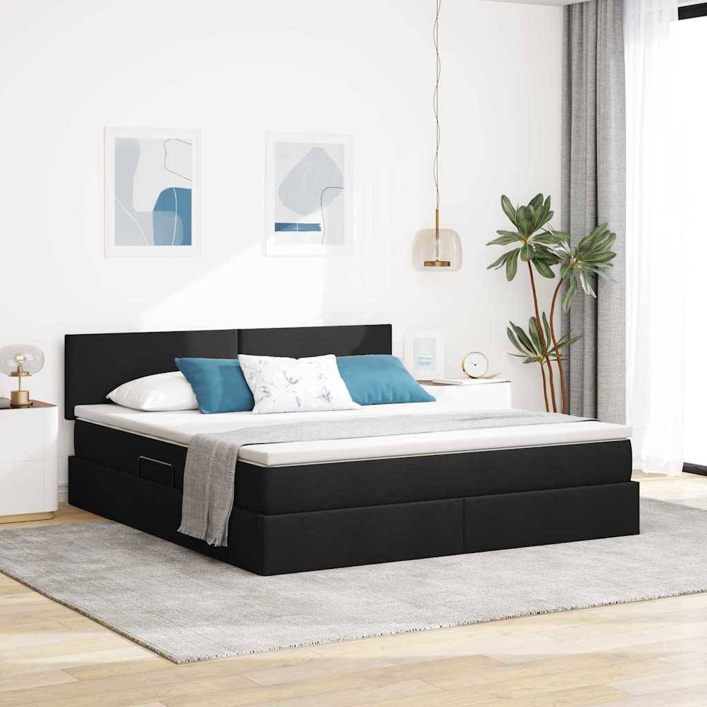 Ein modernes Schlafzimmer zeigt ein schwarzes Podestbett mit weißer Bettwäsche und blauen Akzentkissen, flankiert von minimalistischer Kunst und einer Topfpflanze.