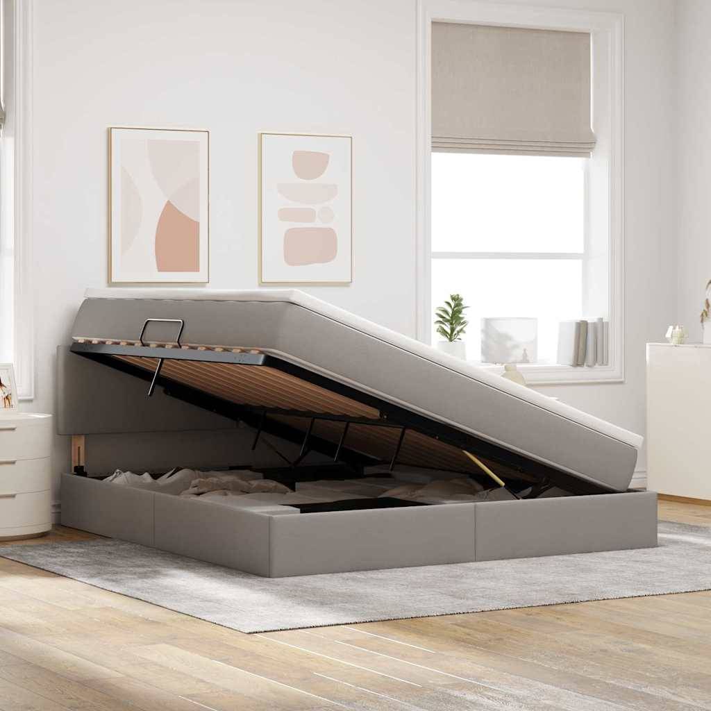 Ein modernes Schlafzimmer zeigt ein graues Bett mit angehobenem Rahmen, das darunter Platz für Stauraum offenbart. Neutrale Einrichtung und natürliches Licht vervollständigen das Ambiente.
