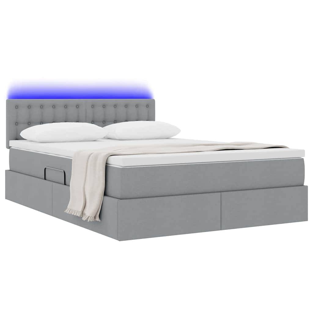 Ein modernes graues Bett mit Schubladen zum Verstauen, einem gesteppten Kopfteil und einer blauen LED-Lichtfunktion. Das Bett ist mit weißen Kissen und einer beigen Wurfdecke eingedeckt.